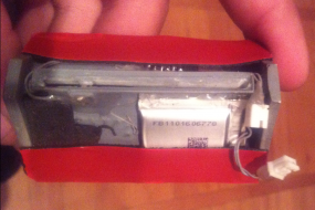 The MSR-605 components combined with a battery and flash drive. The red stuff is 3M double-sided tape.
